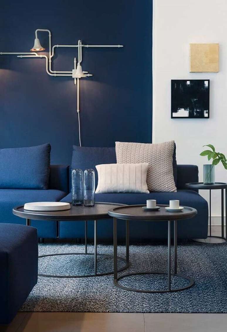 7. Decoração moderna para sala com mesa de apoio redonda e sofá azul escuro – Foto: Pinterest