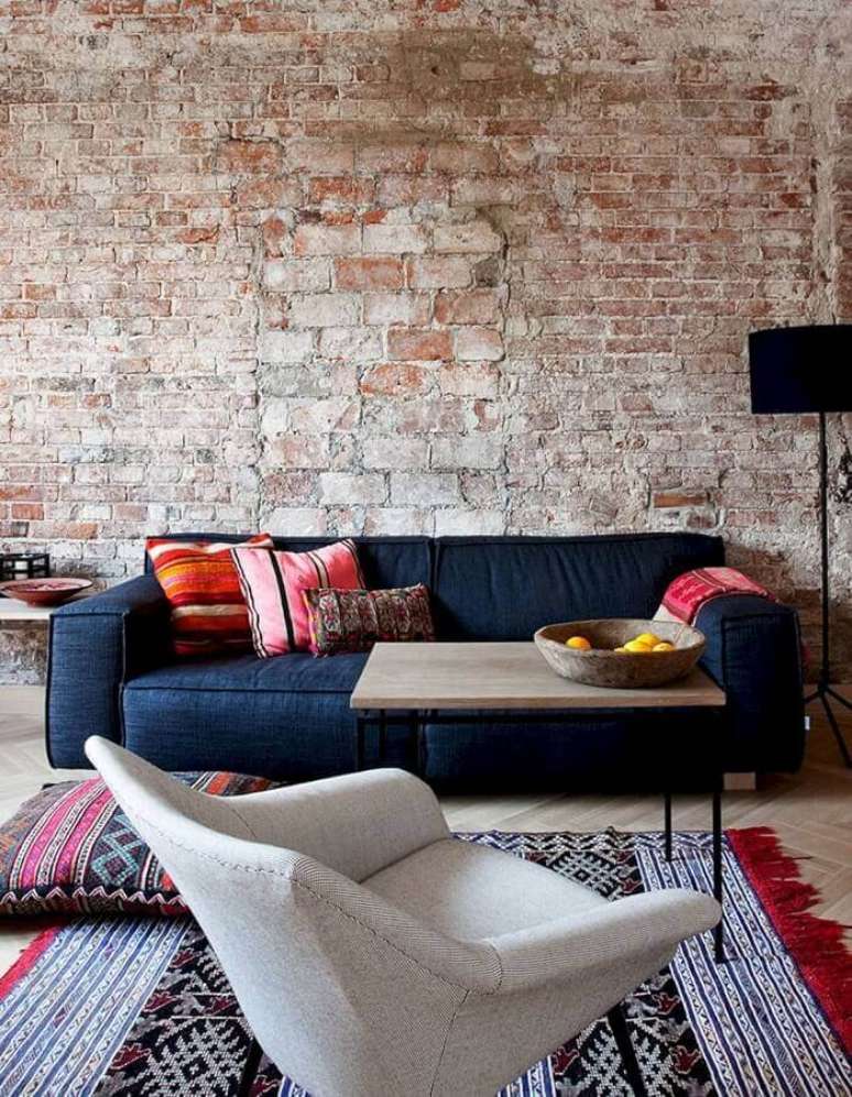 29. Decoração rústica para sala com parede de tijolinho e sofá azul marinho – Foto: Yandex