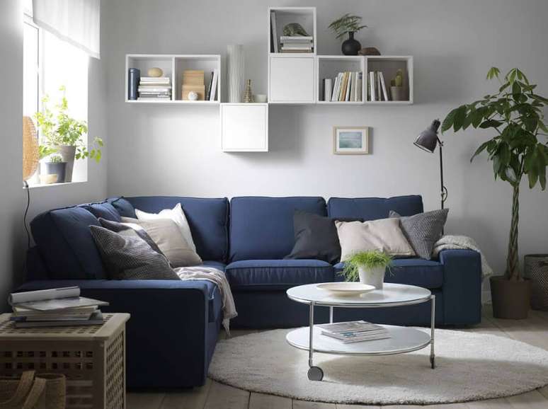 42. Decoração simples para sala com sofá de canto azul e tapete redondo – Foto: Pinterest
