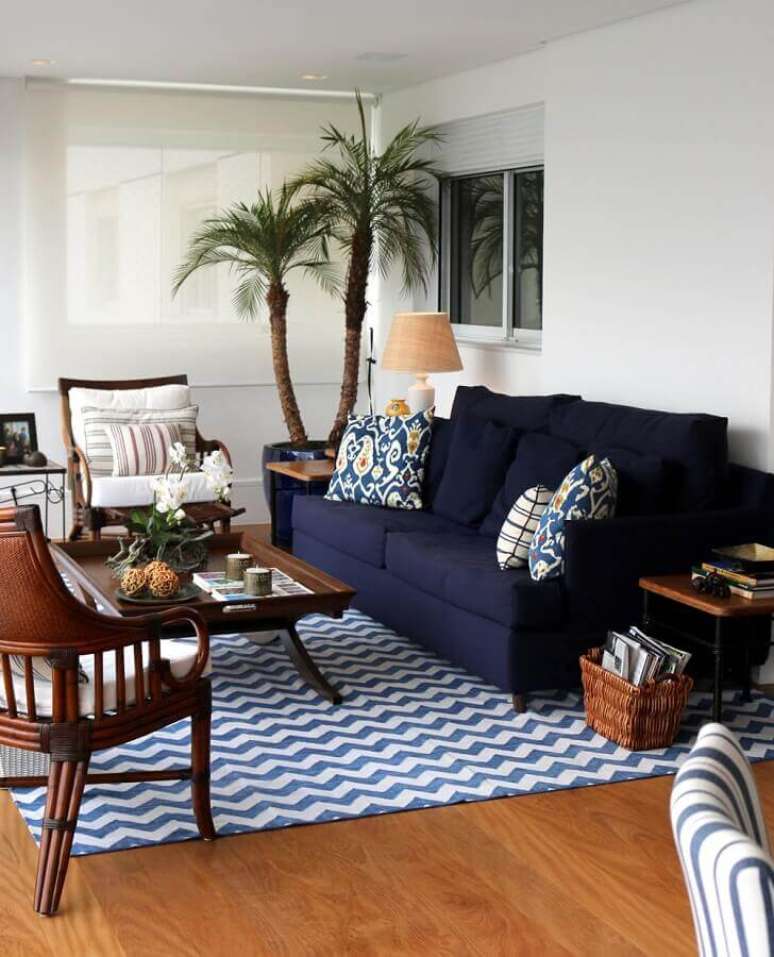 43. Sala de estar decorada com poltronas de madeira e sofá azul marinho – Foto: Casa de Valentina