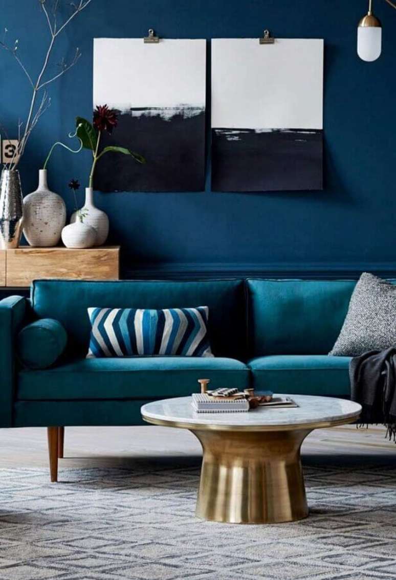 46. Sala decorada com sofá azul petróleo e mesa de centro dourada – Foto: Boutique de décoration