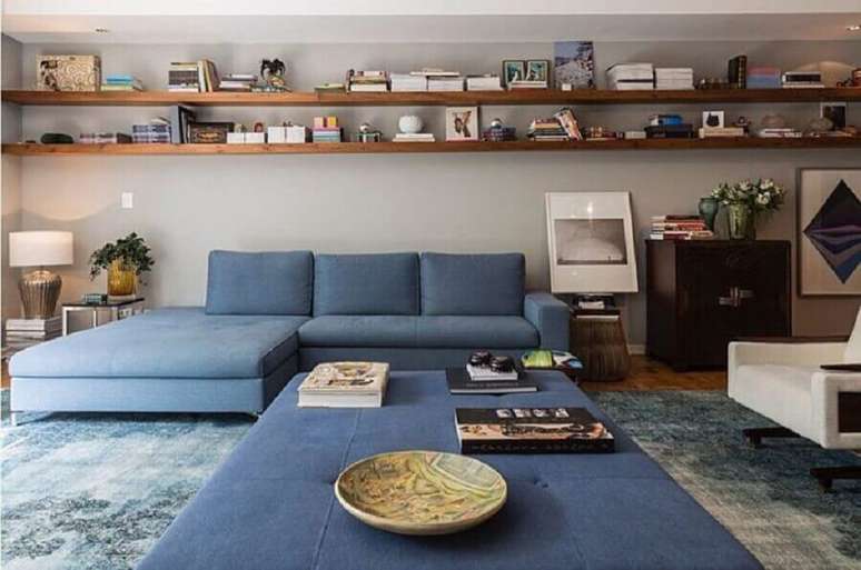 50. Sala ampla decorada com sofá azul claro e prateleiras de madeira – Foto: Juliana Fabrizzi Arquitetura