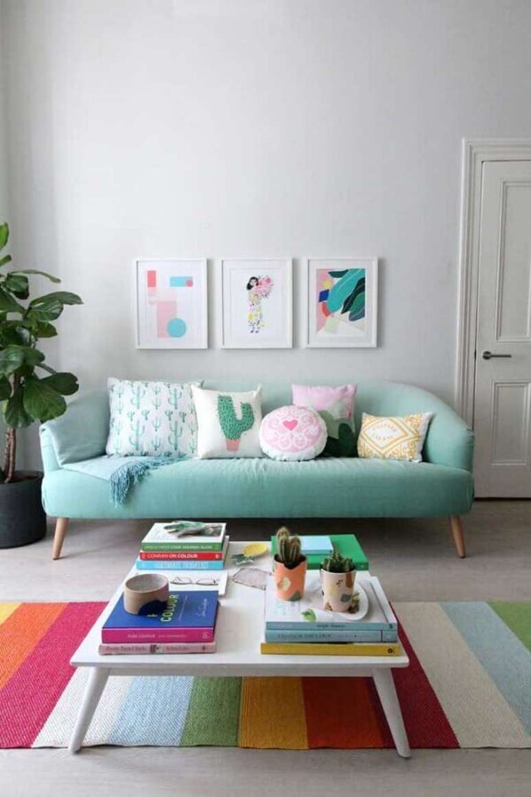 51. Sofá azul claro para decoração de sala com tapete listrado colorido – Foto: HappyShappy