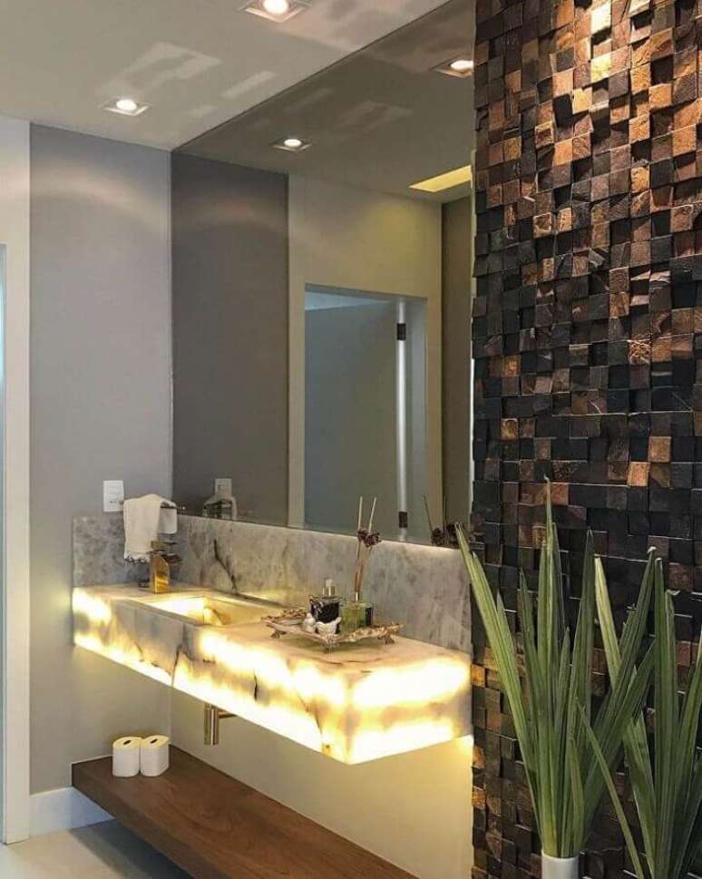 12. Decoração para banheiro com bancada com iluminação embutida e pedra ferro – Foto: Ximene Villar