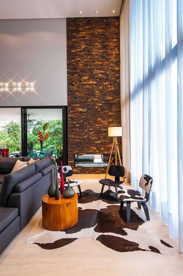 8. Decoração sofisticada para sala de estar com lareira e revestimento pedra ferro – Foto: Galeria da Arquitetura