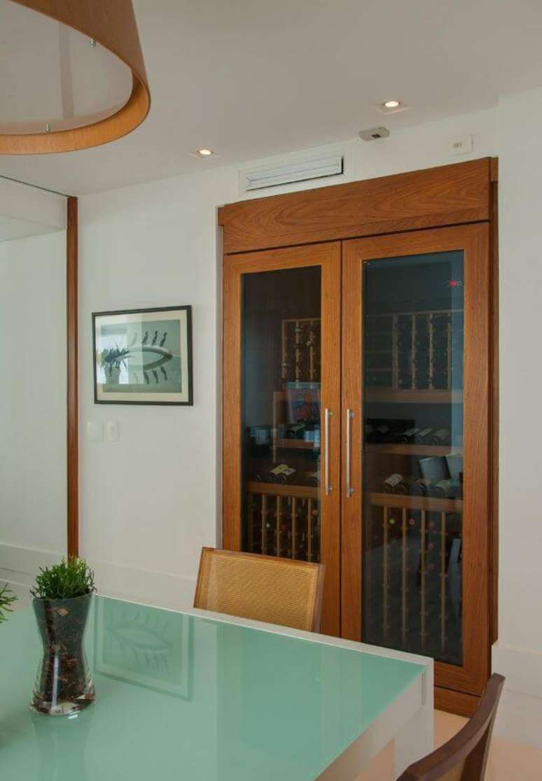 18. Adega de madeira com portas de vidro para sala de estar – Por: In House