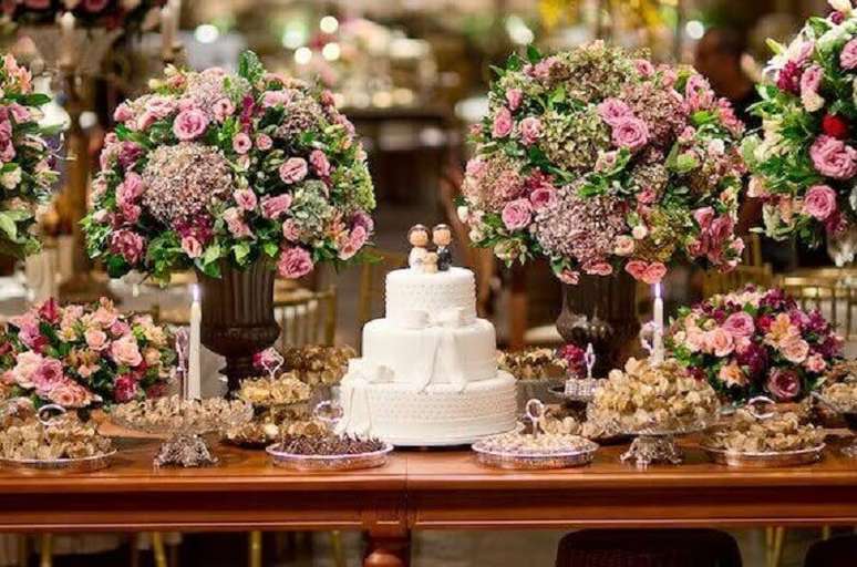 11. Arranjo com muitas flores para mesa de bolo de casamento – Foto: Meu Casamento