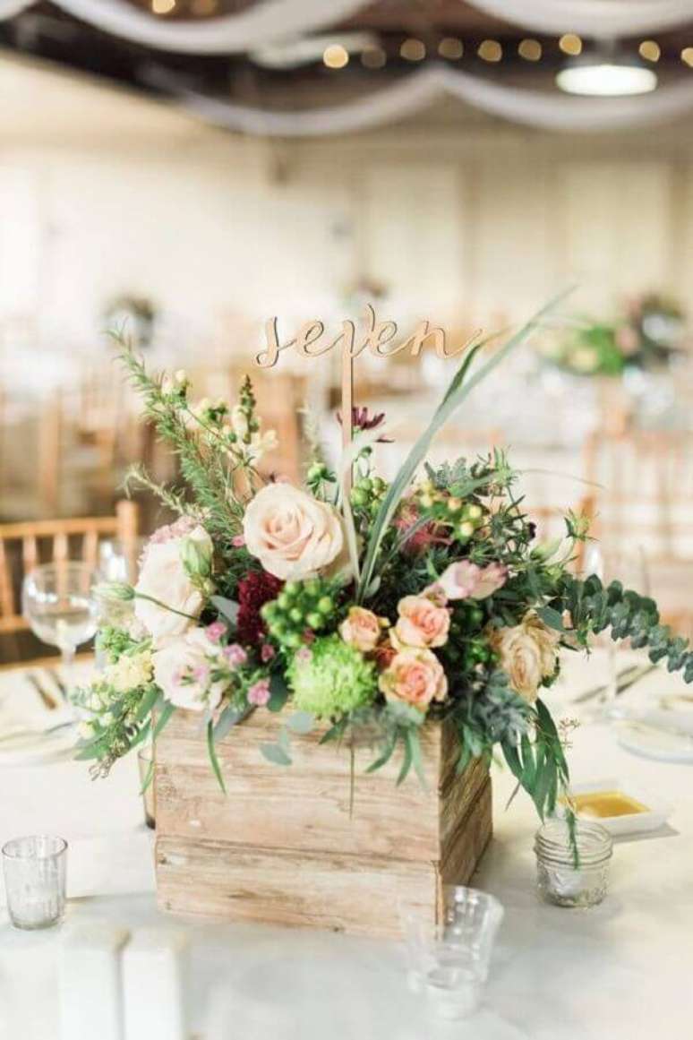 35. Decoração com enfeite de mesa para casamento simples com arranjo de flores dentro de caixote de madeira – Foto: Etsy