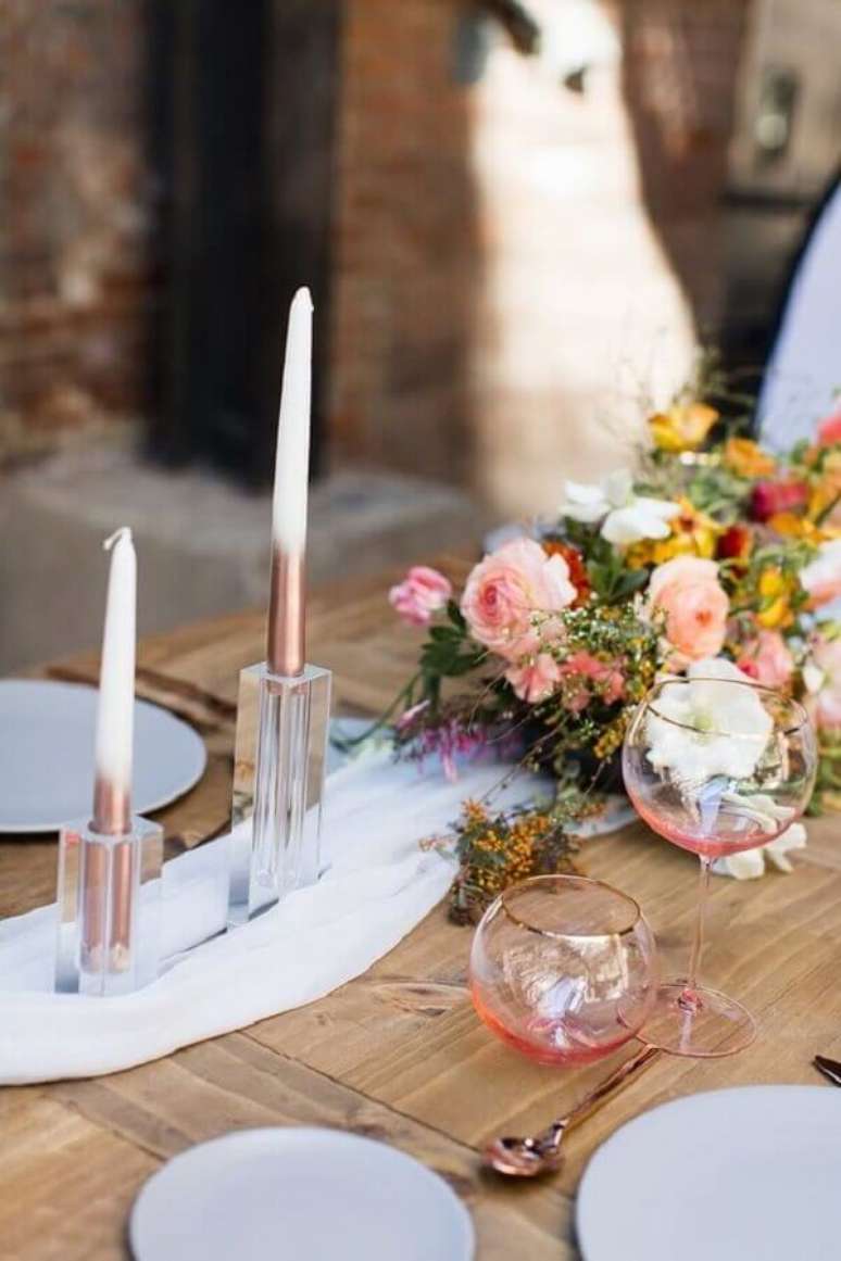 34. Enfeite de mesa para casamento simples com arranjo de flores e velas – Foto: 100 Layer Cake