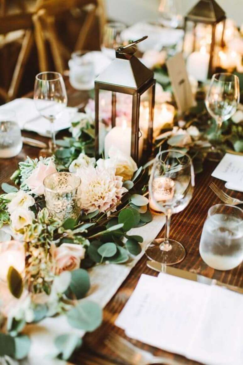 48. Linda decoração com enfeites para mesa de casamento com arranjo de flores e lanternas com velas – Foto: Architectural Home Styles