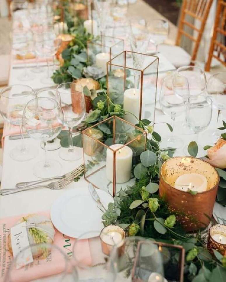 49. Enfeites de casamento para mesa de convidados com folhagens, velas em potes de vidro e detalhes em cobre – Foto: Wedding Fashion