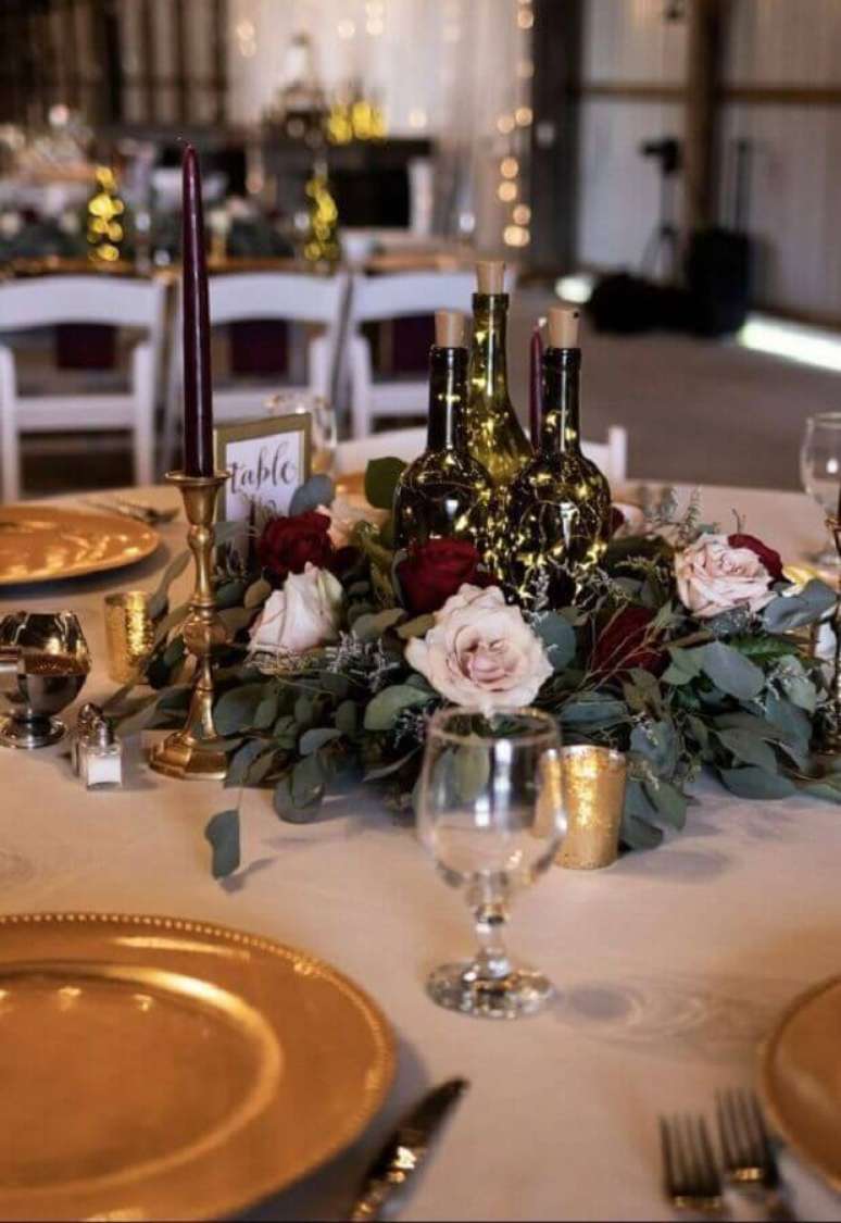 53. Os enfeites de mesa para casamento com garrafas de vidro podem ganhar luzinhas de pisca pisca e flores para deixá-los ainda mais interessante – Foto: Pinterest