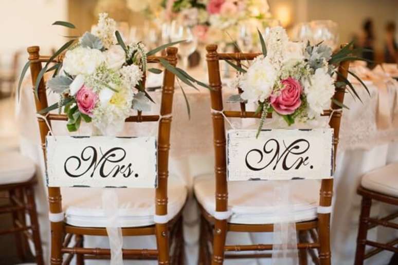 52. Plaquinhas de casamento para cadeira dos noivos e arranjo de flores. Fonte: Internovias