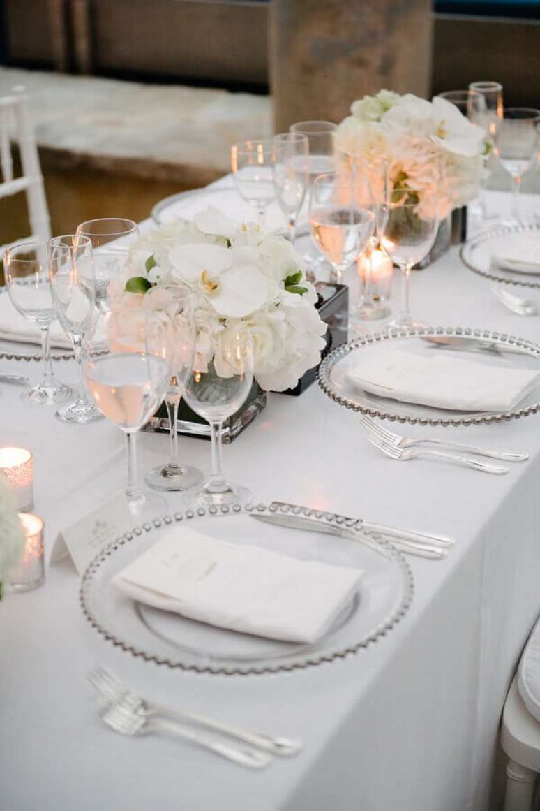 63. Simples enfeite de mesa para casamento com flores brancas e velas – Foto: Style Me Pretty