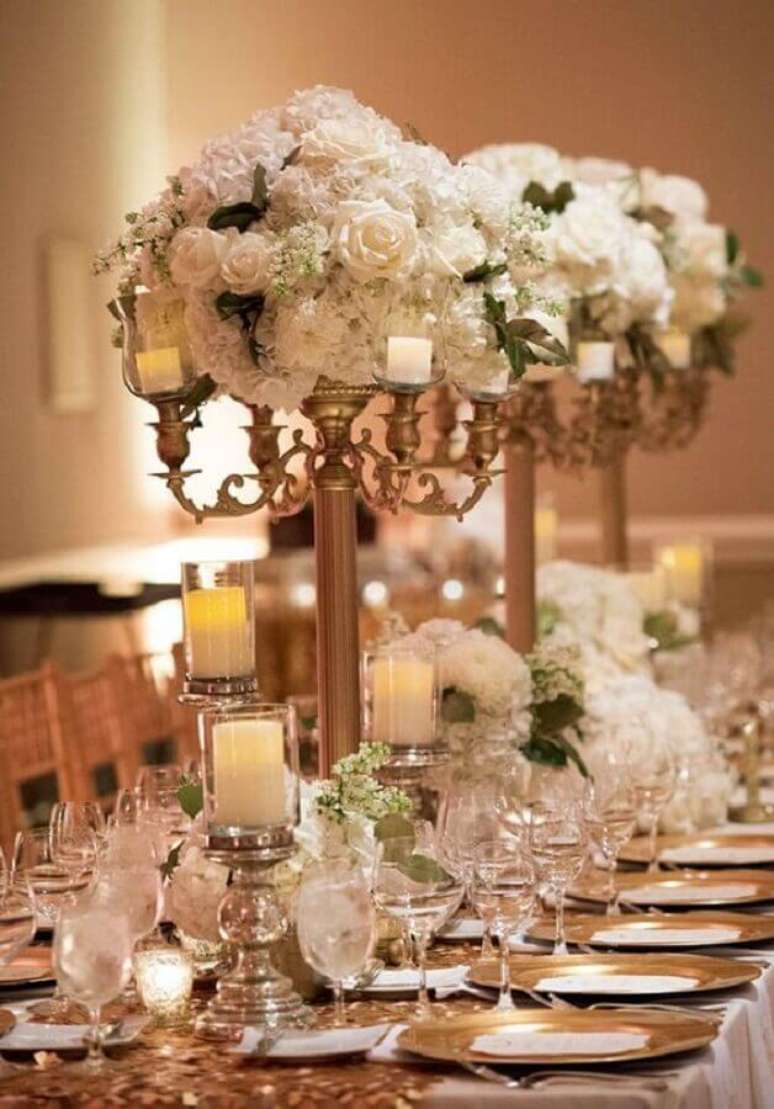 1. Decoração sofisticada com enfeites de mesa para casamento com arranjos de rosas brancas e muito dourado – Foto: Pinterest