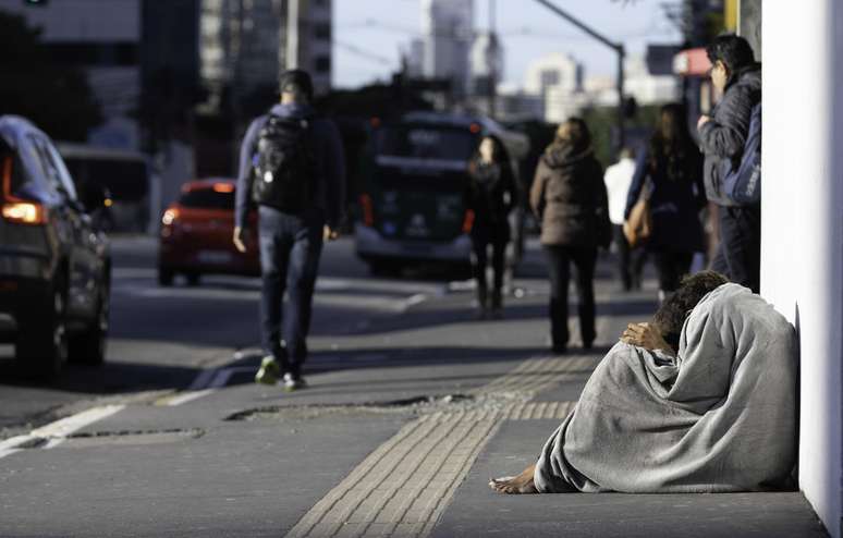 Morador de rua tenta se proteger do frio no Viaduto Santa Generosa, zona sul de São Paulo, na manhã deste sábado, 6