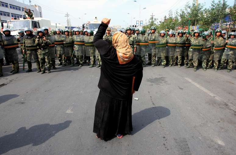 Mulher grita em frente a soldados de tropa de choque da China em Urumqi, na Região Autônoma de Xinjiang
07/07/2009
REUTERS/David Gray