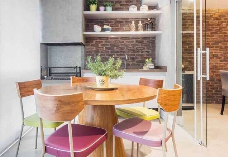 12. Decoração para espaço gourmet com mesa redonda de madeira e parede de tijolinho – Foto: Pinterest