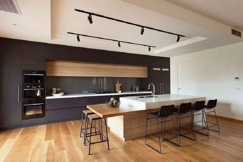 39. Decora&ccedil;&atilde;o moderna para espa&ccedil;o gourmet amplo com bancada de madeira e spots de luz &ndash; Foto: R.Z. Owens Constructions