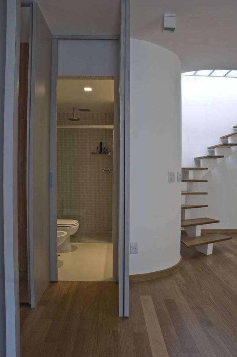 24. Sala com piso de madeira e escada com degraus do mesmo material. Projeto de Arquiteto Donini