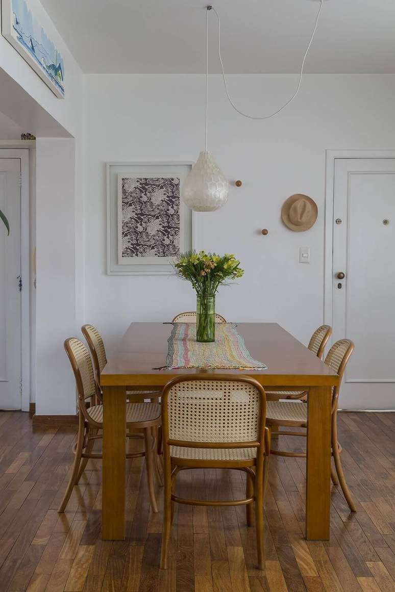 52. Sala de jantar com piso de madeira e mesas e cadeira do mesmo material. Projeto de Leila Dioniz