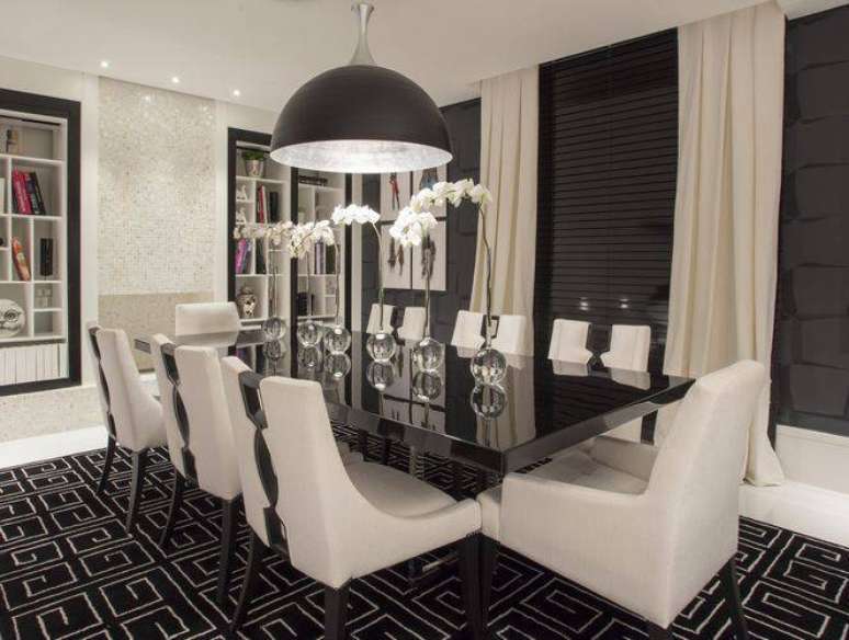 19. Sala com mesa de jantar preta e cadeiras aconchegantes na cor branca. Projeto por Erica Salguero