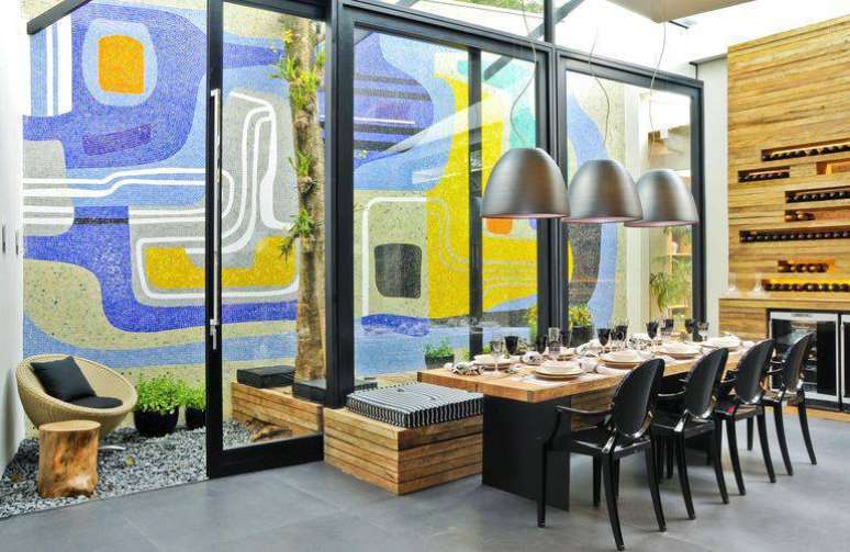 20. Mesa de jantar com ferro e madeira, fazendo conjunto com cadeiras Ghost pretas e um banco. Projeto por Mari Ani Oglouyan