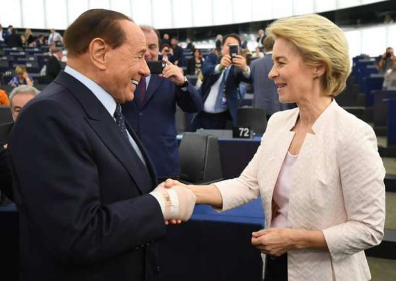 Silvio Berlusconi, com a mão enfaixada, cumprimenta a nova presidente da Comissão Europeia, Ursula von der Leyen