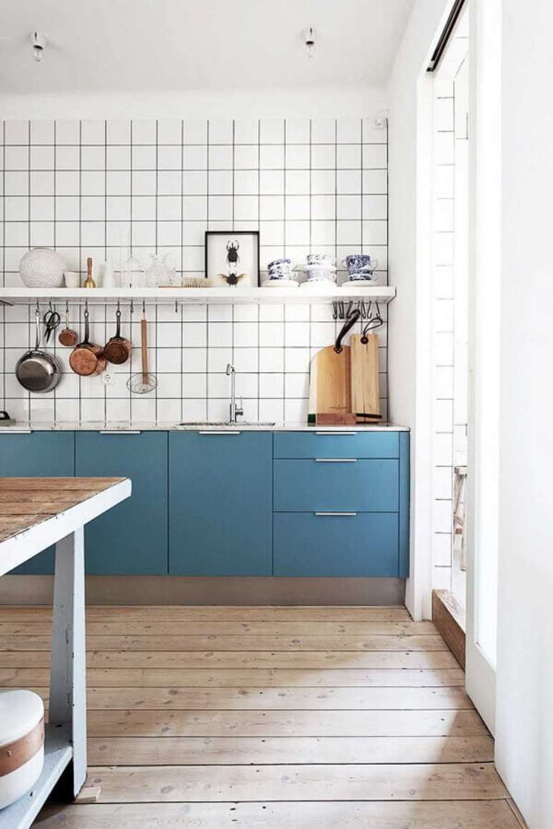 18. Cozinha simples decorada com armário planejada azul petróleo e piso de madeira – Foto: Apartment Therapy