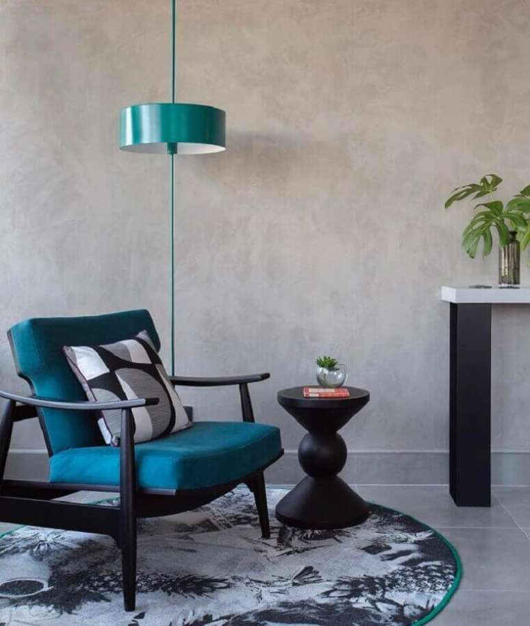 27. Ambiente decorado com parede de cimento queimado e poltrona azul petróleo – Foto: Melina Romano Interiores