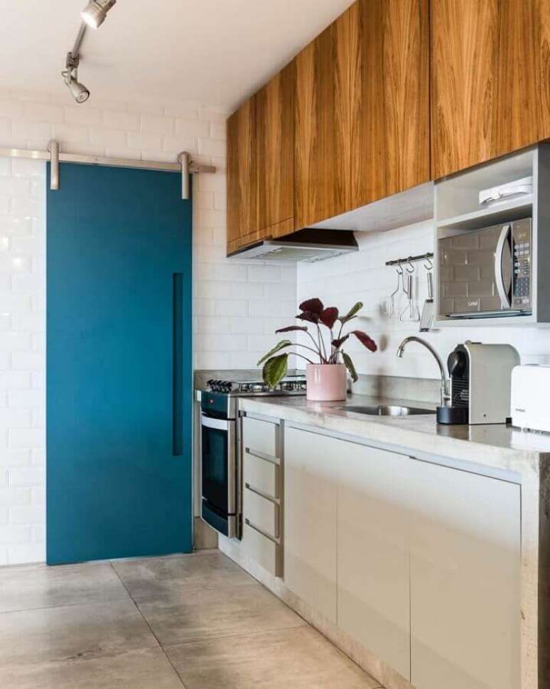 30. A porta azul petróleo deu um toque de cor para a cozinha com decoração clean – Foto: Manore Arquitetura e Urbanismo