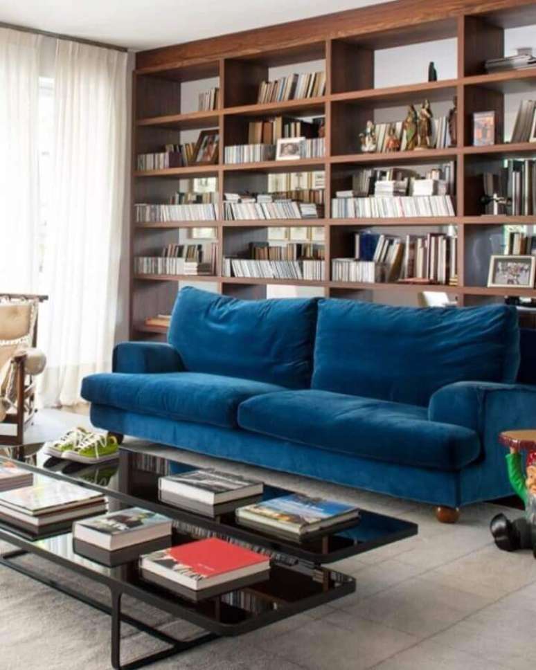 35. Decoração de sala com estante de madeira planejada e sofá azul petróleo – Foto: Antonio Ferreira Junior