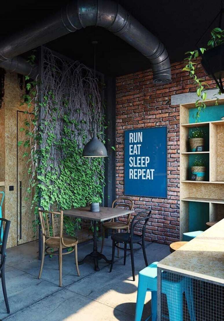 6. Decoração estilo industrial para ambiente com parede de tijolinho e quadro azul petróleo – Foto: Pinterest