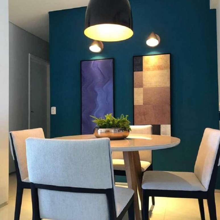 52. Sala de jantar decorada com mesa pequena redonda e tinta de parede azul petróleo – Foto: Tassia Carvalho