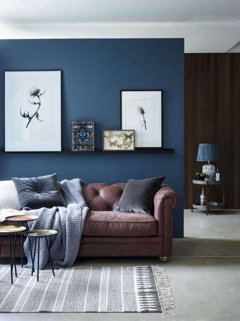 68. Sala decorada com parede azul petróleo e quadros de diferentes tamanhos – Foto: La Maison Jolie