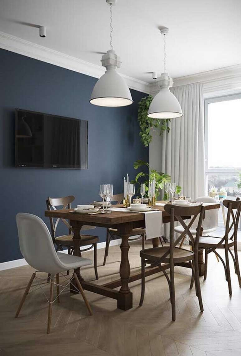 71. Tinta de parede azul petróleo para sala de jantar com mesa de madeira e pendentes brancos – Foto: Behance
