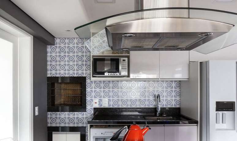 23. Cozinha com coifa de vidro em parede de azulejo decorativo