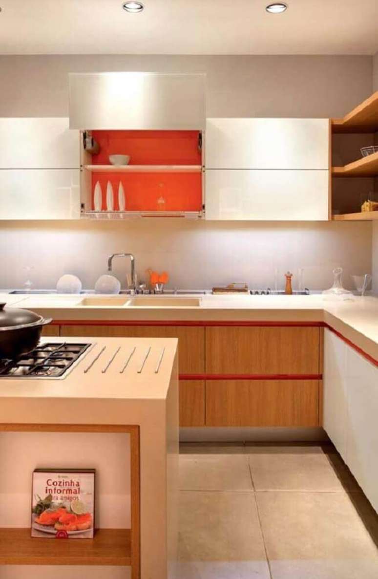 3. Decoração clean com armário de cozinha planejado com acabamento laranja por dentro