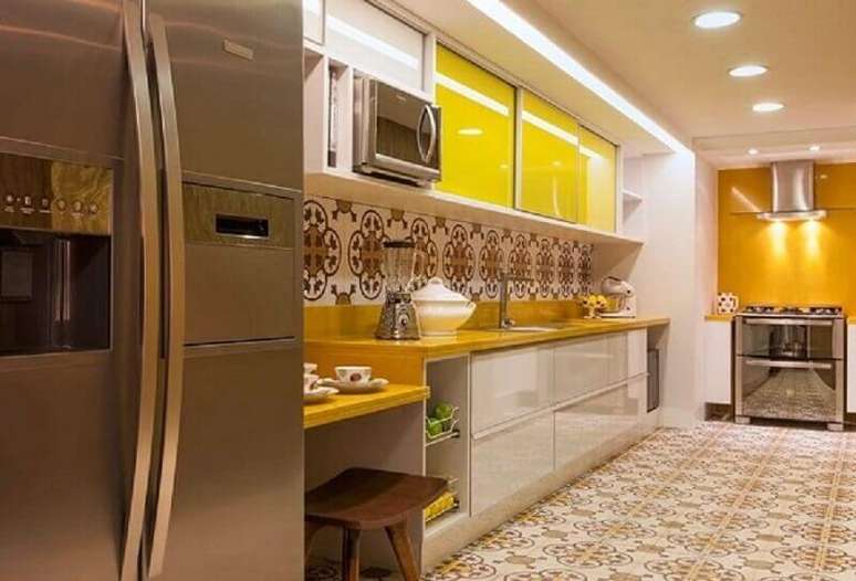 58. Essa cozinha recebeu bastante cores devido as portas dos armários de cozinha amarelas e o piso hidráulico