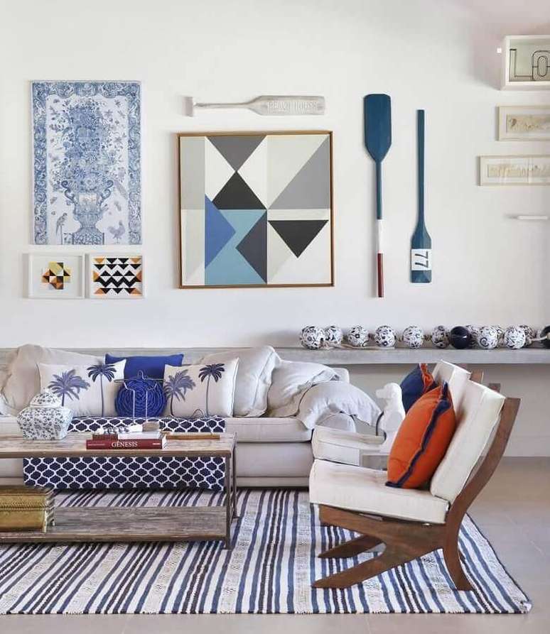 45. Decoração de sala branca e azul com quadros e tapete listrado – Foto: Dcore você