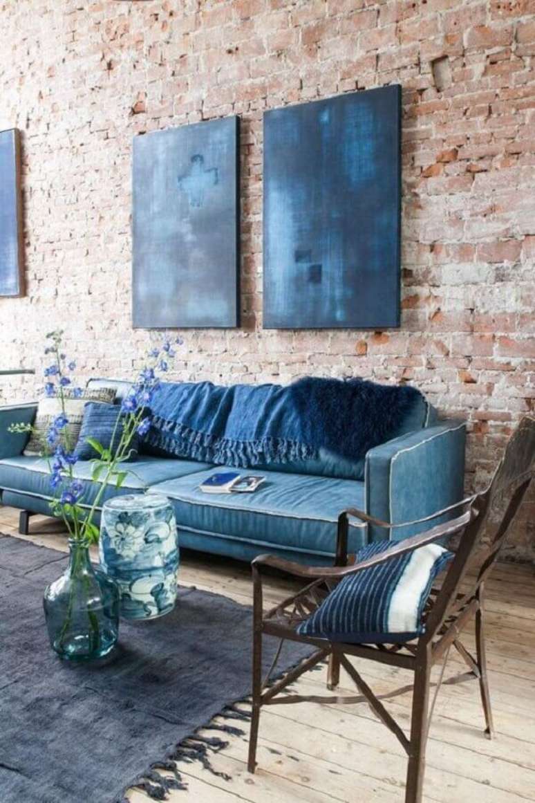 74. Tapete para sala decorada com sofá azul e parede de tijolinho – Foto: Planete-deco