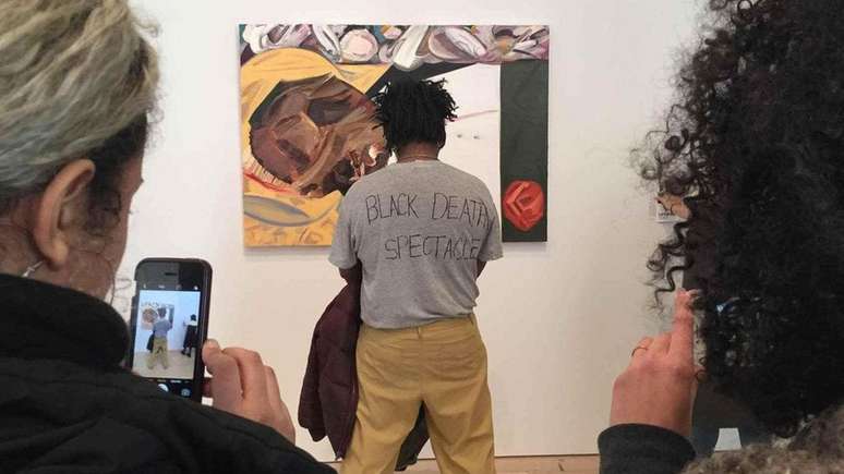 O artista Parker Bright protestou contra a pintura de Dana Schutz de uma vítima de linchamento ao obstruir a visão da obra (Crédit: Twitter)