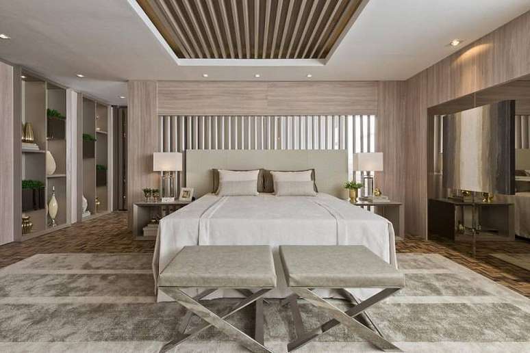 22. Em uma parede com muitos detalhes uma cabeceira de casal de madeira lisa pode ser a op&ccedil;&atilde;o para harmonizar. Projeto por Casacor2016.