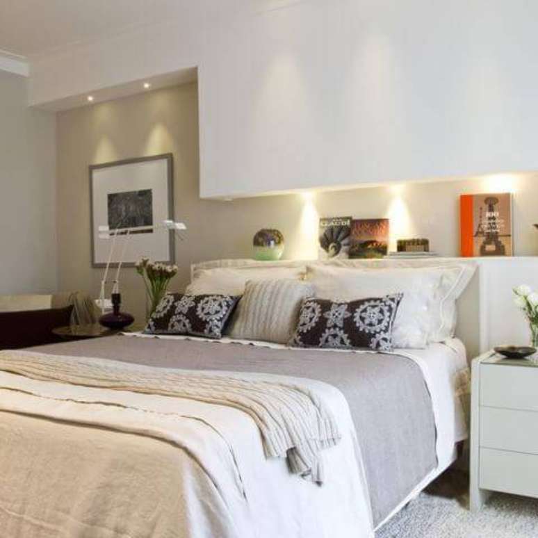 44. A cabeceira de casal associada &agrave; prateleira feita em gesso com ilumina&ccedil;&atilde;o &eacute; diferente e super criativa. Projeto por Marilia Veiga.