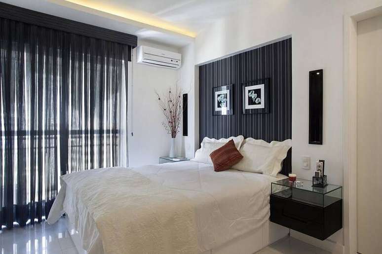 50. Fazer uma parede de gesso com a &aacute;rea da cabeceira de casal e revesti-la de papel de parede tamb&eacute;m &eacute; uma alternativa comum. Projeto por Elaine Fonseca.