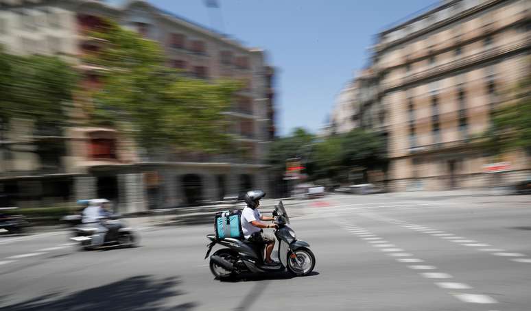 Entregador da Deliveroo numa scooter percore ruas de Barcelona. 23/7/2019. REUTERS/Albert Gea 