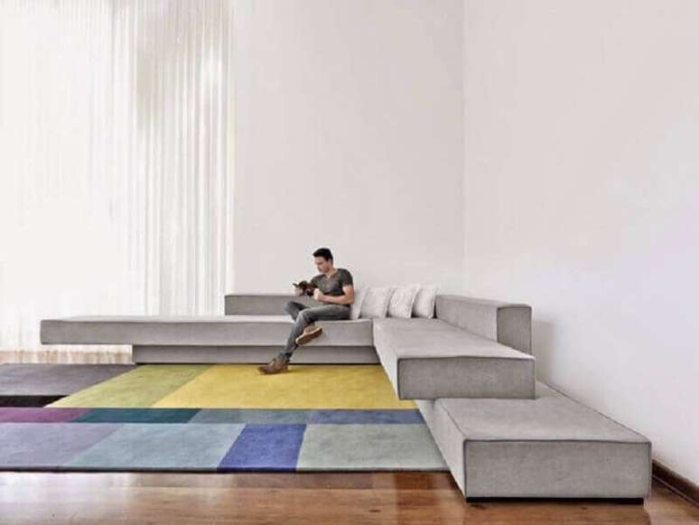13. Decoração para ambiente amplo com sofá de canto moderno e tapete colorido – Foto: Arquitectura y Diseño