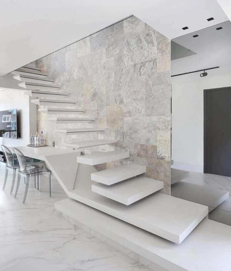 57. Escada flutuante branca com estrutura que se transforma em base de mesa. Fonte: Breves Arquitetura
