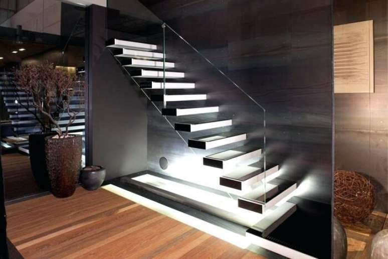 70. Escada flutuante de concreto com lateral de vidro e iluminação sofisticada. Fonte: Pinterest