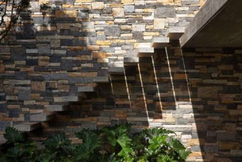 66. Escada com degrau flutuante de concreto da área externa fixada na parede de pedra. Fonte: Pinterest